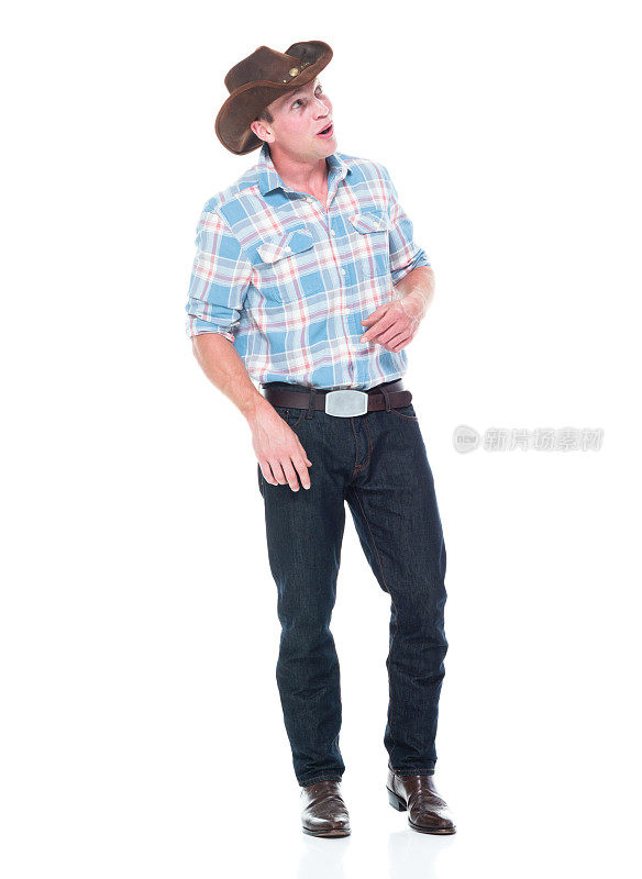 正面图/ 20-29岁的白人青年/男性牛仔站在白色背景前，穿着牛仔靴/牛仔帽/牛仔帽/伐木工人衬衫